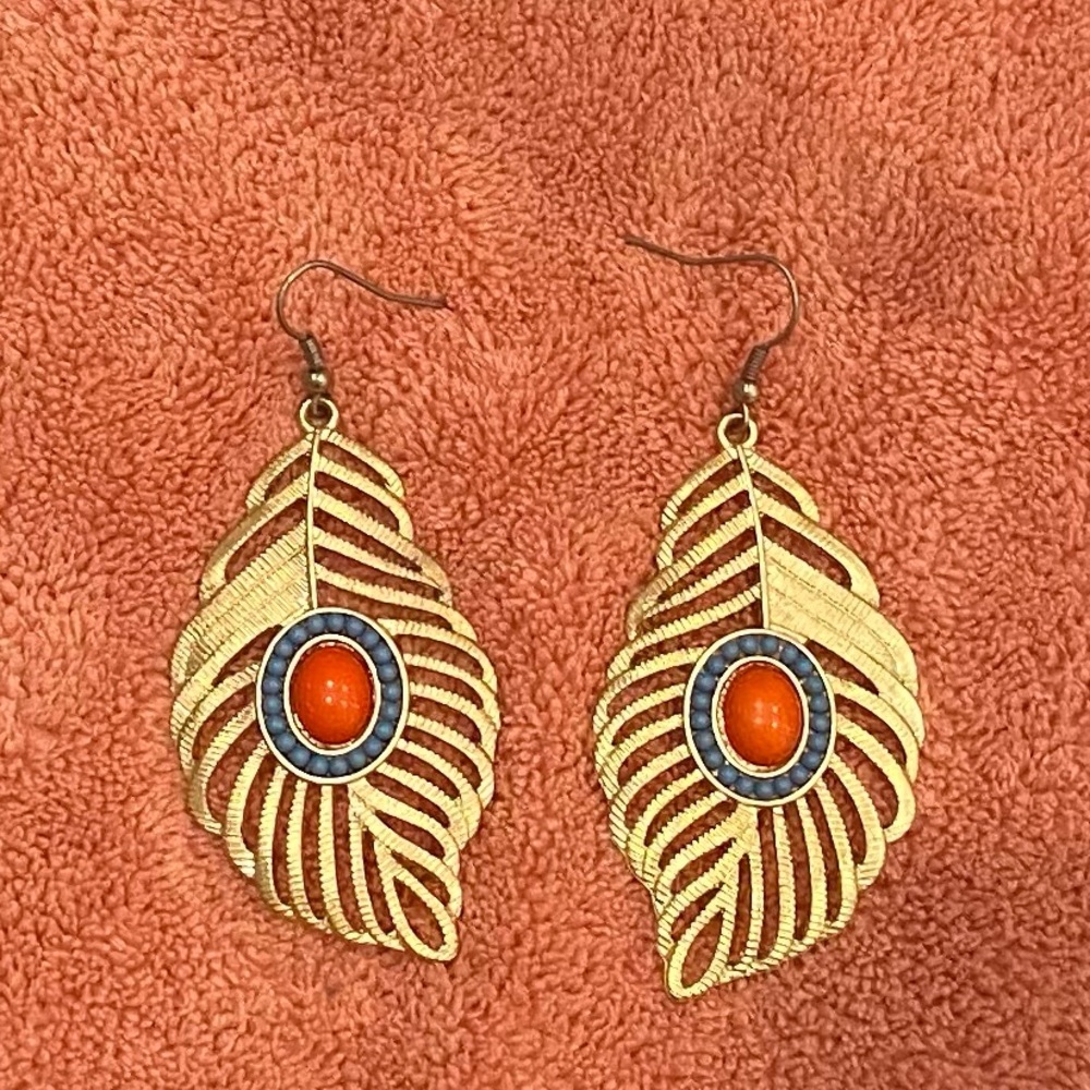 Gold feather earrings with turquoise and orange stones.